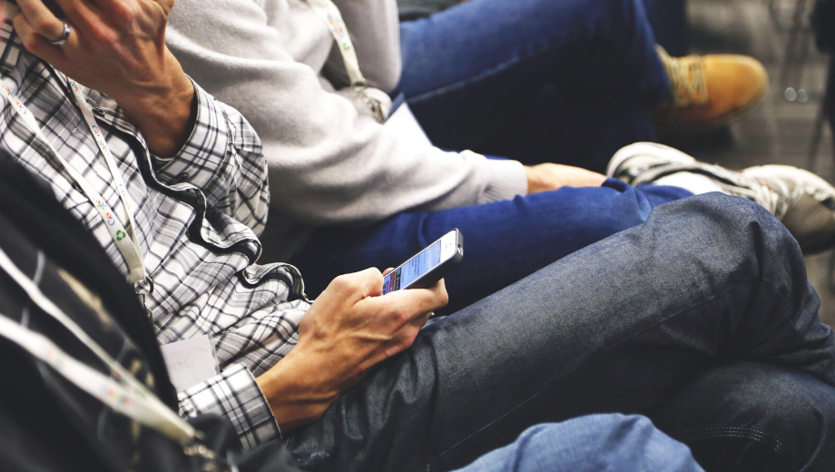 Two men sitting with their cell phones in their hands