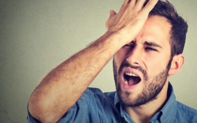 Angry man holds his hand to his forehead