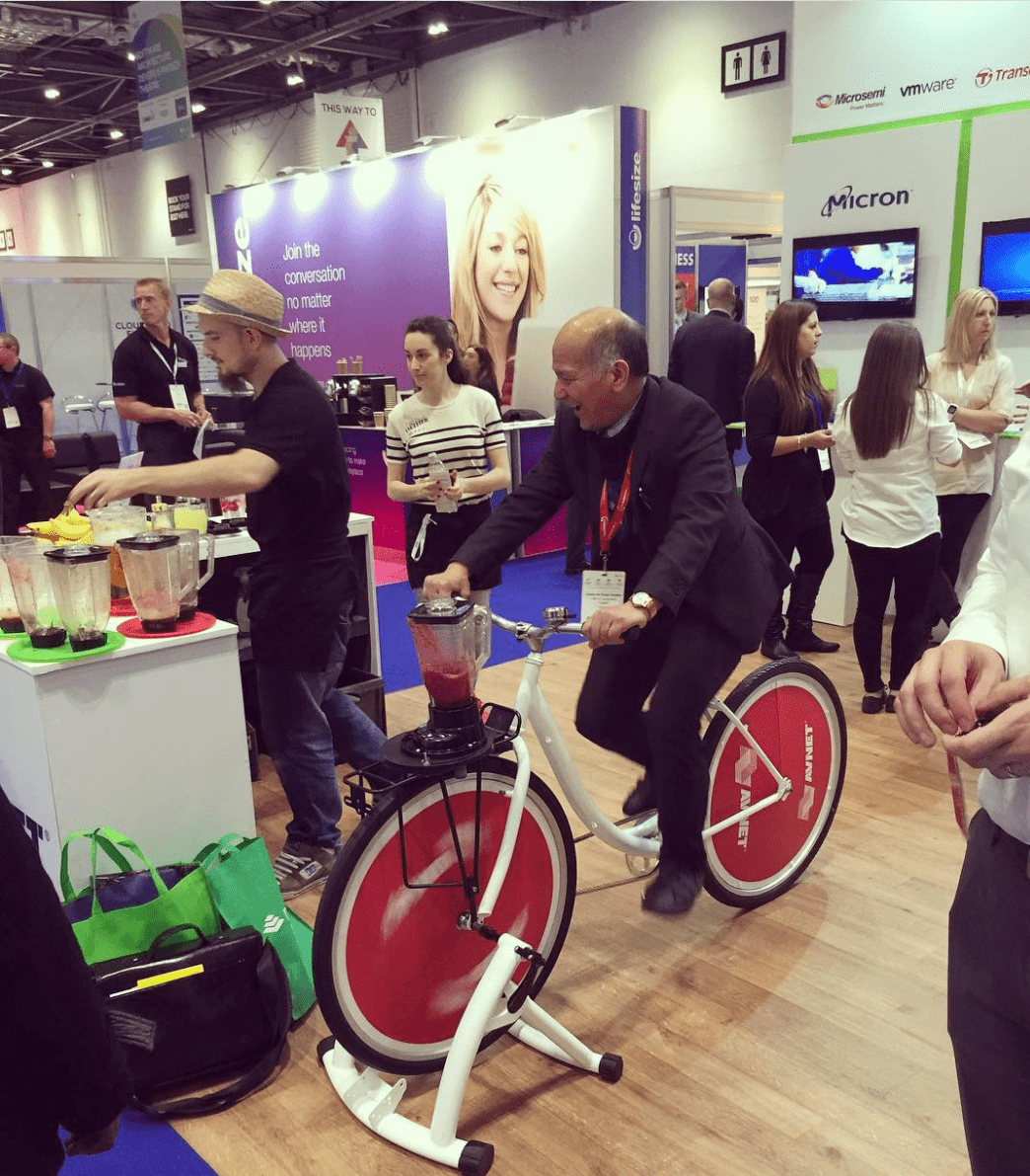 sponsor booth with a stationary e bike that people jump on 