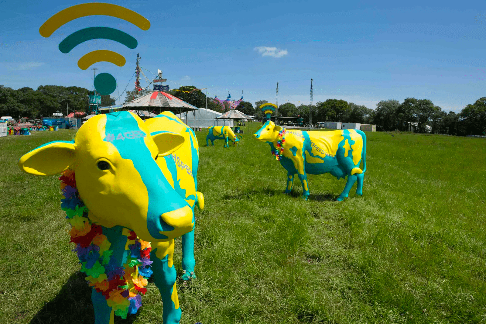 sponsored green and yellow cows that function as wifi hotspots on a outdoor event